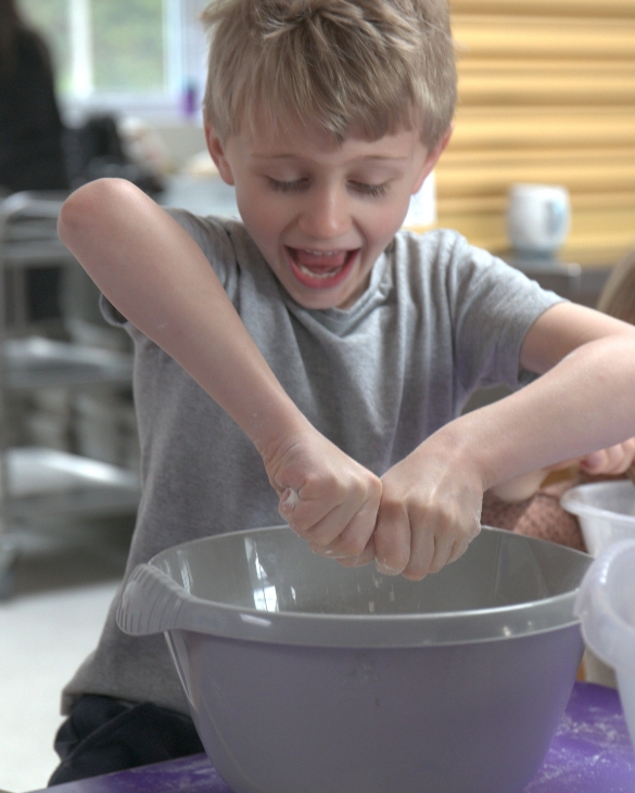 boy learning cooking skills at cookery club